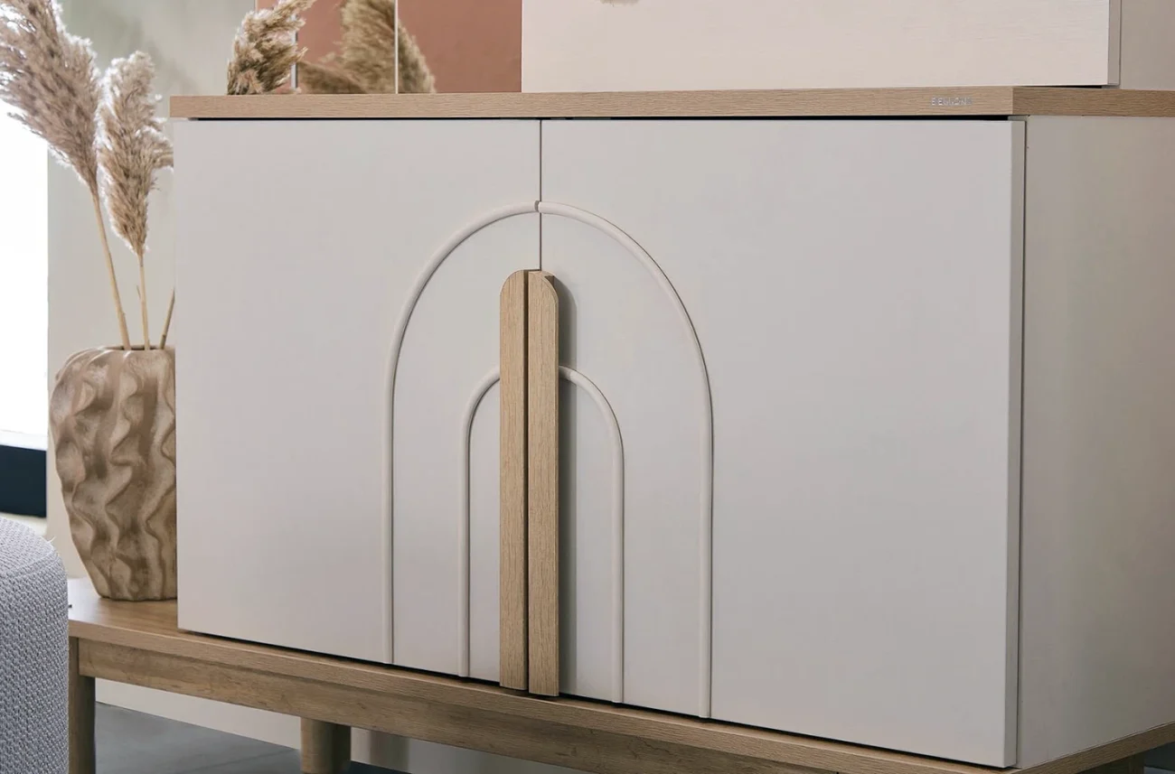 Prim-plan al fațadei dulapului Boheems cu frezare decorativă în formă de arc și mâner din lemn