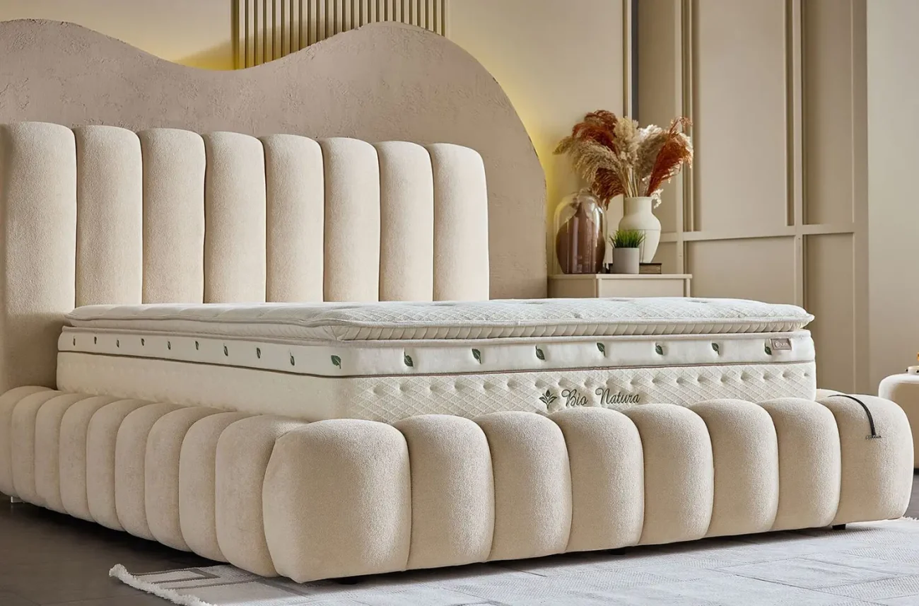 Detaliu al texturii materialului si formei bombate a patului Bio Natura in nuante calde de bej