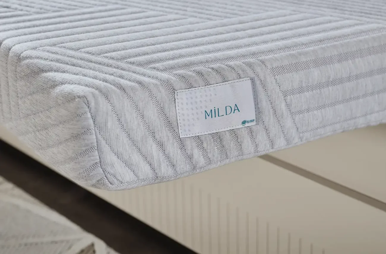 Logo-ul mărcii MILDA pe partea laterală a saltelei ortopedice pentru copii