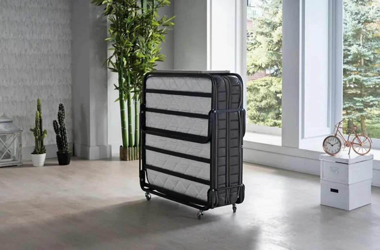 Depozitare verticală a patului pliant pentru oaspeți Easy pliabil pe suporturi cu role în cameră