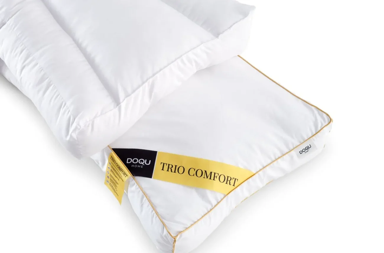 Doua perne anatomice albe Trio Comfort asezate suprapus pe fundal neutru