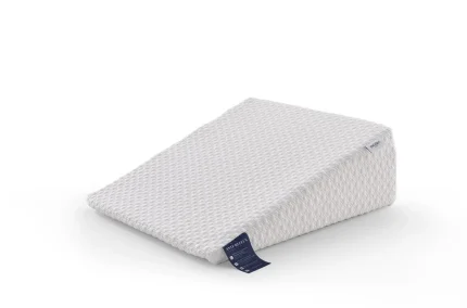 Pernă înclinată Anti-Reflux de culoare albă cu formă ergonomică pentru somn pe fundal deschis