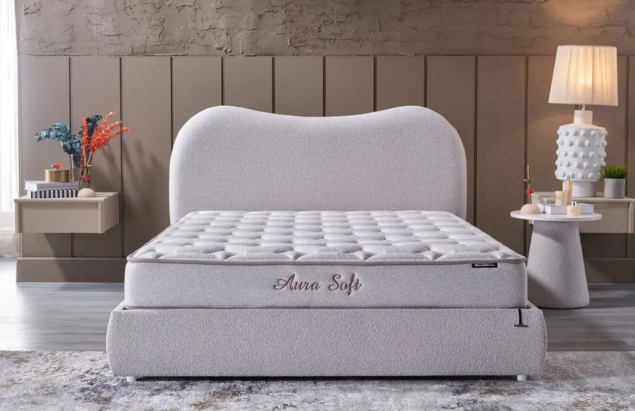 Saltea premium Aura Soft cu tăblie curbată și accesorii elegante într-un interior modern de dormitor luminos