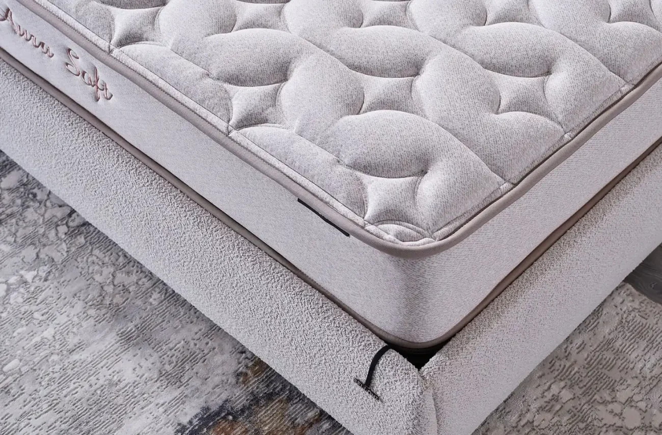 Vedere asupra colțului și marginii saltelei Aura Soft care prezintă înălțimea și finisajul premium al produsului