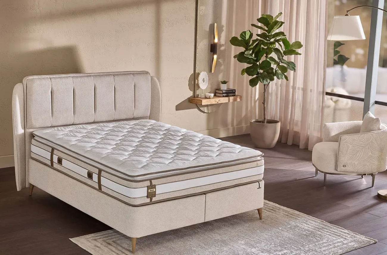 Vedere laterală a patului cu saltea înaltă Gold Prestij într-o cameră luminoasă și primitoare